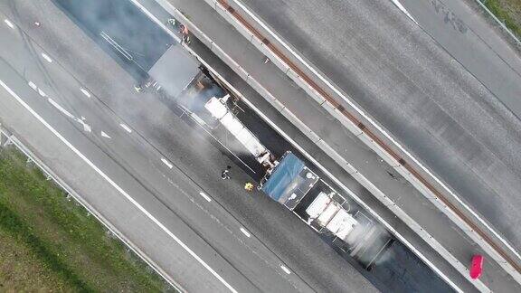 沥青摊铺机和蒸汽压路机在道路建设和维修工程中沥青和铺装过程中工人在新道路施工现场工作放置一层无人机