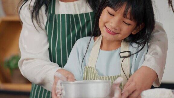 亚洲小女孩喜欢在家里的厨房里和奶奶、妈妈一起学习烹饪、烘焙快乐的奶奶妈妈和小女儿在厨房里家庭与烹饪理念