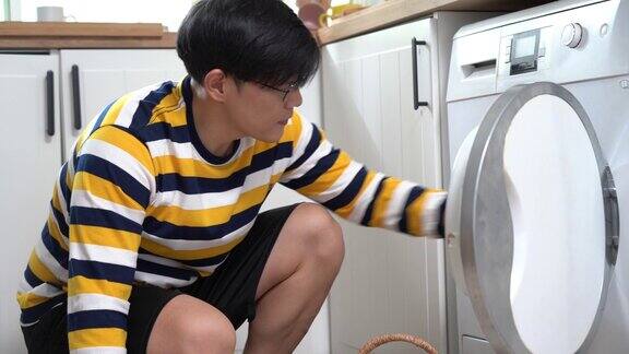 亚洲男子在洗衣房洗衣服