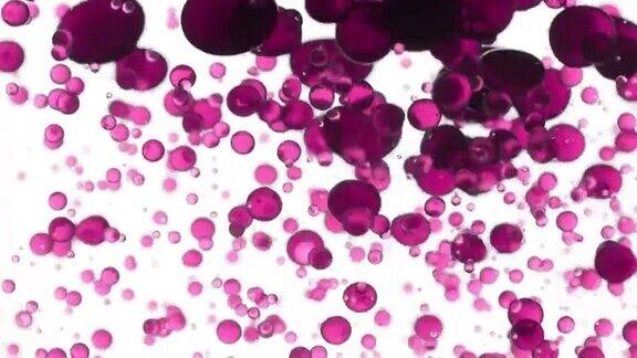 将玫瑰油倒入水中产生粉红色的气泡