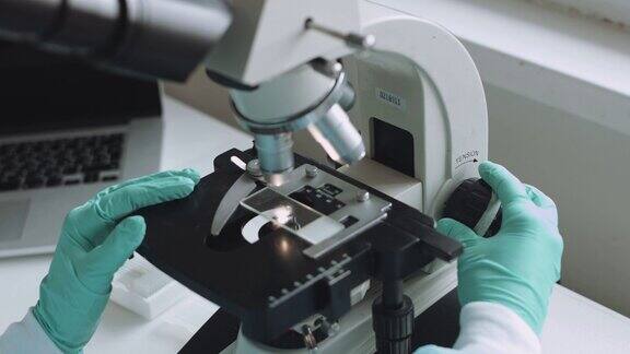 在实验室用显微镜工作的科学家