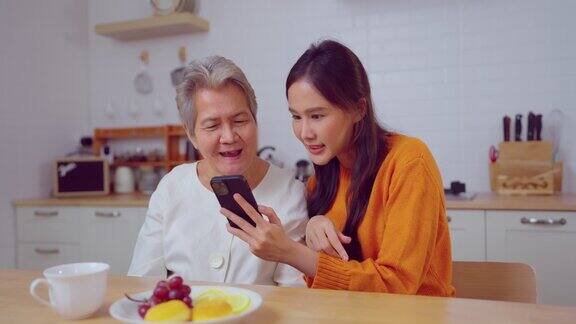 年轻的亚洲女人在家里和年长的女人打电话