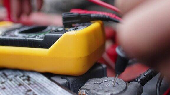 修车技师检查汽车蓄电池电压