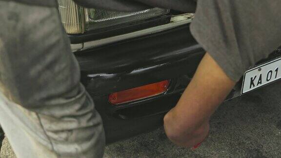 一个人在使用期间擦拭或清洁汽车保险杠的特写
