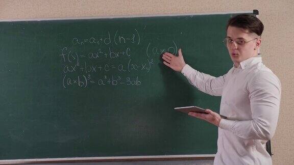 一个学生站在写着数学公式的黑板旁边