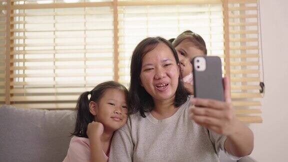 有两个女儿的母亲喜欢在家用智能手机视频通话