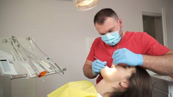 牙医用口腔镜和牙科挖掘机检查病人的牙齿