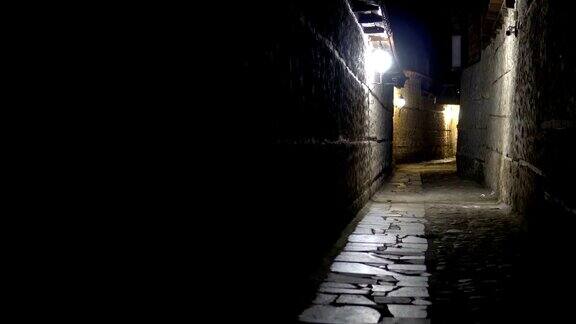 神秘狭窄的小巷石头铺砌的路灯在晚上