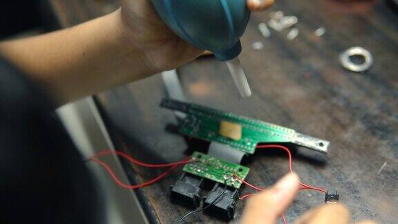 十几岁的男孩用手鼓清洗电子电路板