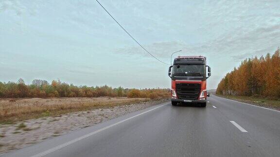 在多车道道路上单独行驶的带有货物拖车的卡车的正面视图