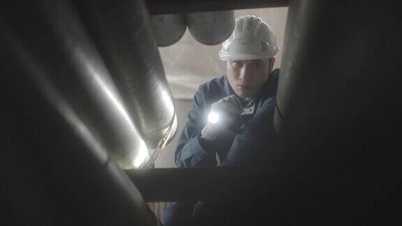 钢铁厂工人用手电筒检查