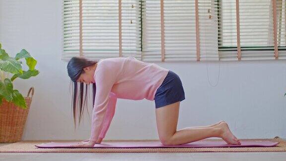 健康的平静运动亚洲妇女练习瑜伽猫牛姿势冥想在家里的卧室在早上醒来后感觉如此舒适和放松保健概念