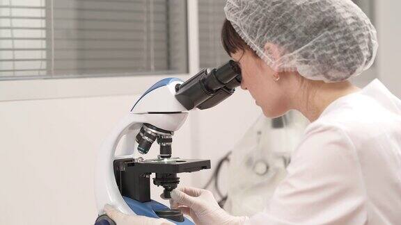 在实验室里使用显微镜的科学家研究人员检查人类生物样本医学研究