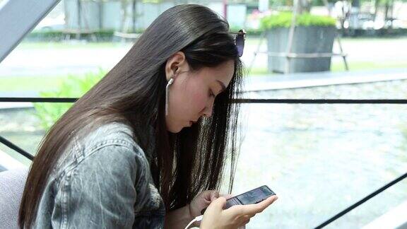 欧亚年轻的亚洲女性在智能手机上打字的镜头