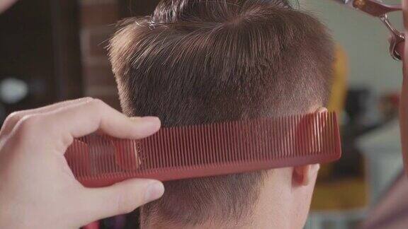 理发师在理发店用剪刀剪头发的慢动作特写