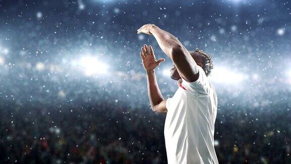 一名足球运动员在下雪的职业球场上庆祝胜利并愉快地飞吻