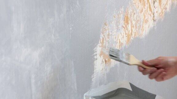 平刷在墙上画上灰色房屋油漆工用手用油漆刷接近