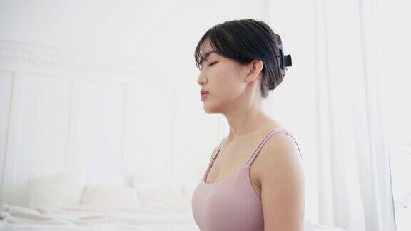 一个运动的亚洲女人的特写吸气呼气在瑜伽垫上练习瑜伽做莲花练习半莲花姿势冥想穿着运动服4k实时视频
