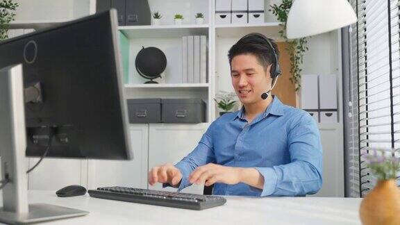 亚洲商人使用笔记本电脑视频电话与办公室同事帅气的专业男员工坐在桌子上开会脑力激荡在公司的工作场所