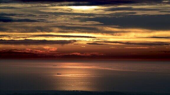 黄昏时天空和大海是橙色和金色的船只和动态云