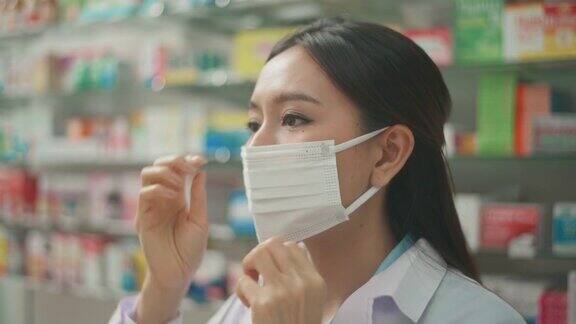 亚洲女药剂师戴着防护面具和实验服在现代药房药房的肖像