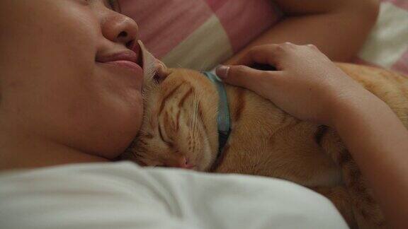 亚洲妇女睡觉和拥抱小猫小猫在家里的床上