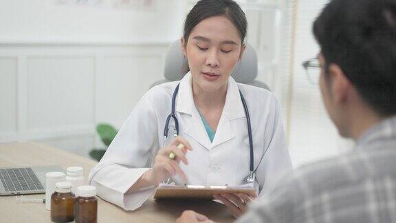 亚洲年轻女医生在诊所或医院与男病人交谈