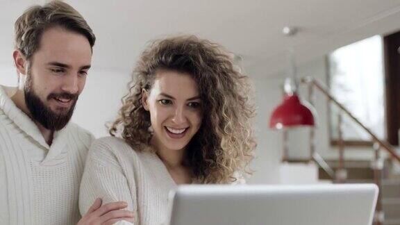 男人和女人在家里使用笔记本电脑