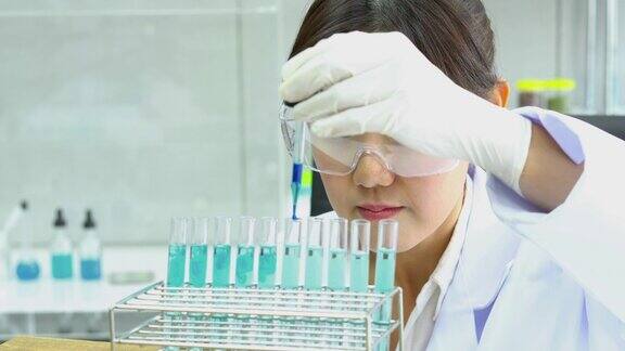 亚洲药剂师正在试验化学化合物并在试管中吸收液体制药、科学、测试开发和实验室产业的理念