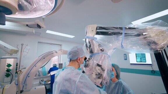 现代手术室里的神经外科医生专业外科医生使用显微镜进行神经外科手术卫生保健