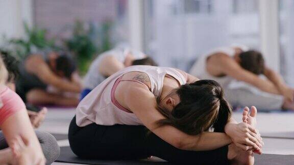 一名年轻女子在健身课上练习瑜伽的4k视频