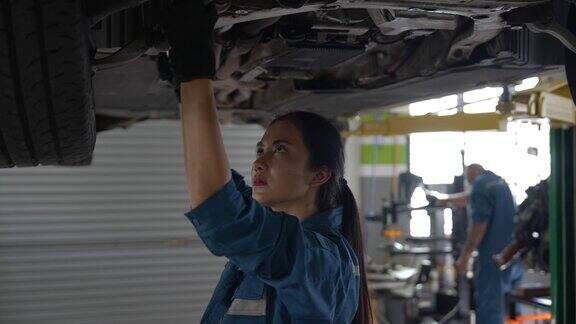 亚洲女性汽车修理工专注于汽车维修