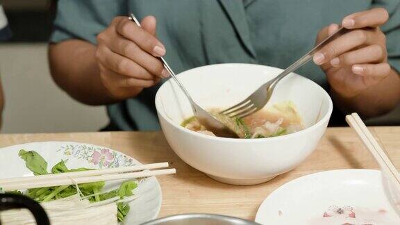 4k特写:一个女人用勺子准备吃的寿喜烧碗