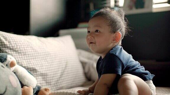 一个婴儿(6-11个月)在家里的床上开心地笑着泰国