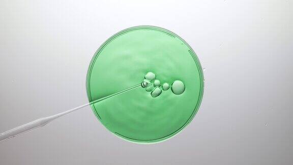 气泡从滴管中出来漂浮在绿色液体的破裂上