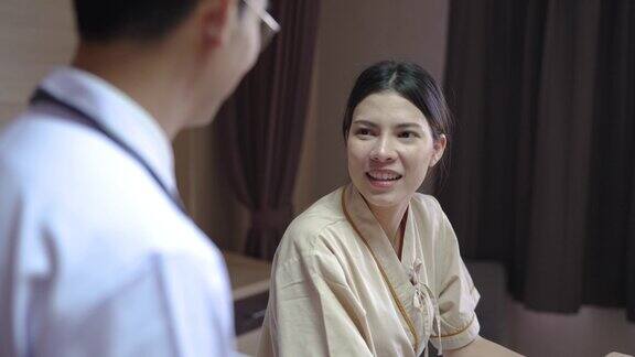 年轻的亚洲男性医生与他的病人愉快的交谈