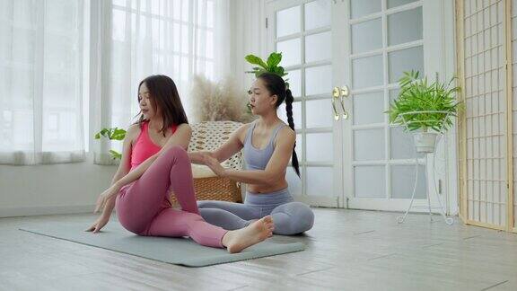 亚洲女性瑜伽老师在课堂上教授学生基本运动、运动理念和健康