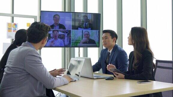 执行业务团队合作会议使用技术在会议室的屏幕上进行在线视频聊天
