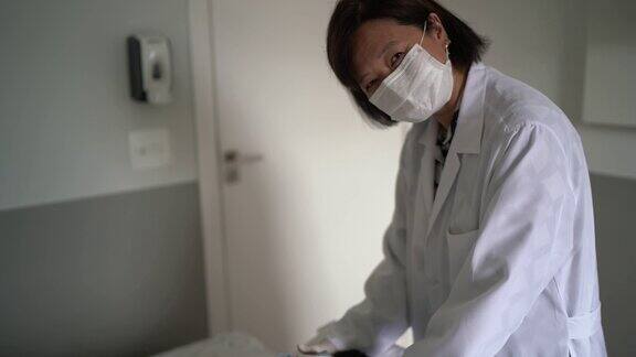 一名医生在医疗诊所治疗病人的肖像戴着防护口罩