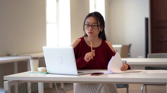 集中亚洲女生在大学阅览室准备考试或做作业