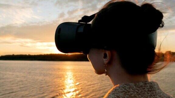 日落时分一名女子在游轮甲板上戴着虚拟现实眼镜