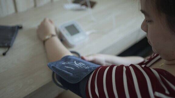 亚洲妇女在家测量血压