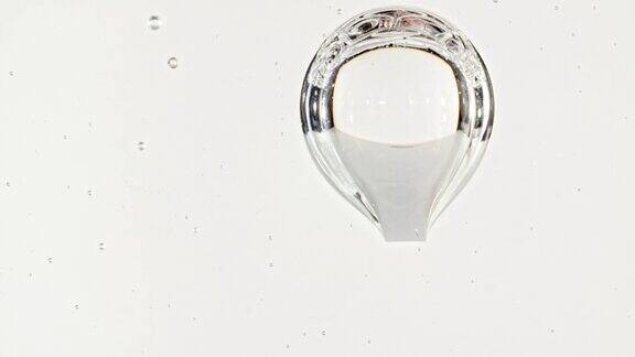 移动气泡的慢动作镜头微距拍摄的各种气泡在水中上升在浅色背景液体奶油凝胶透明化妆品样品纹理泡沫