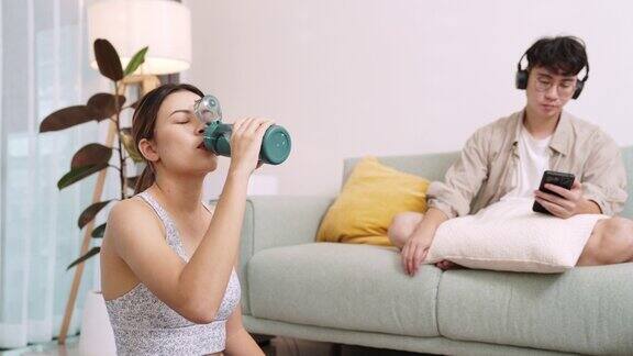健康女性在家运动后喝水