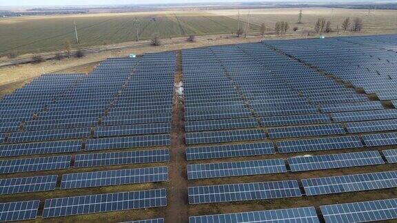 阳光明媚的日子里田野里的太阳能发电厂鸟瞰图太阳能电池板在能源生产领域处于领先地位一架无人机飞过太阳能农场可再生绿色能源替代能源