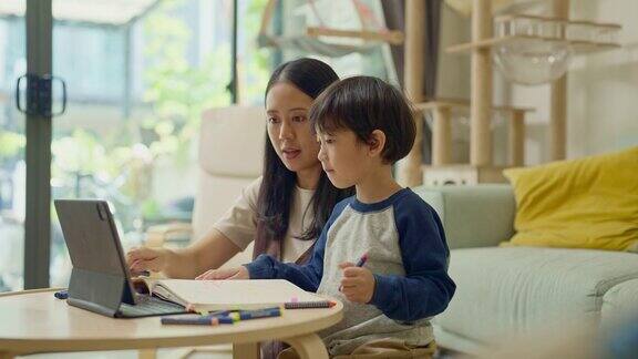母亲一边帮助儿子一边学习