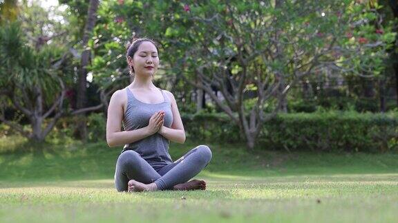 早上在公园里做瑜伽的亚洲女人