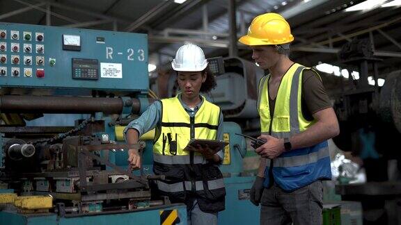 两组非裔美国工业工程师经理女与机械工人男讨论在工业制造大工厂使用平板检测机器现场谈话视察