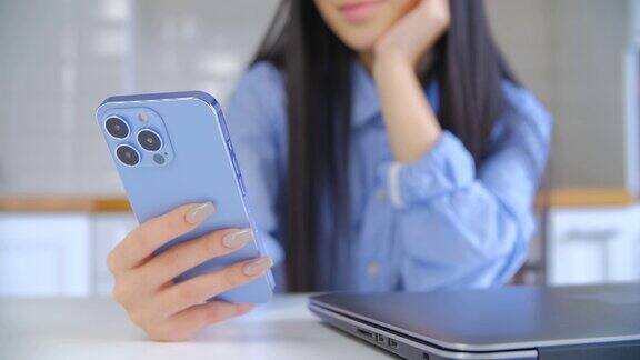 年轻女子使用现代手机亚洲女孩在智能手机上浏览社交媒体应用程序的三摄像头女性在封闭状态下使用互联网技术进行交流和网上购物