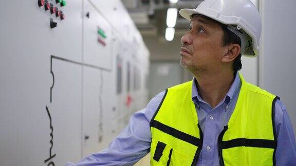 4K亚洲男工程师在工厂服务器电气控制室工作
